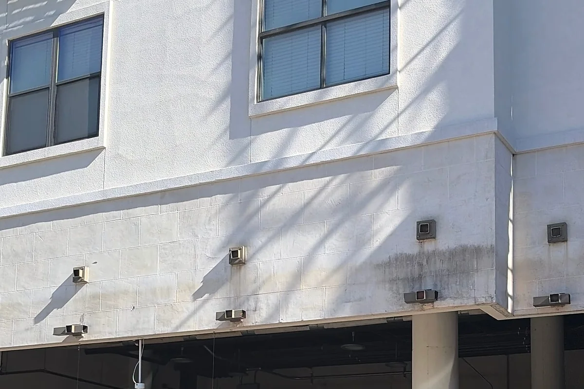 Exposed wall and attachment areas above a garage opening after awning removal.