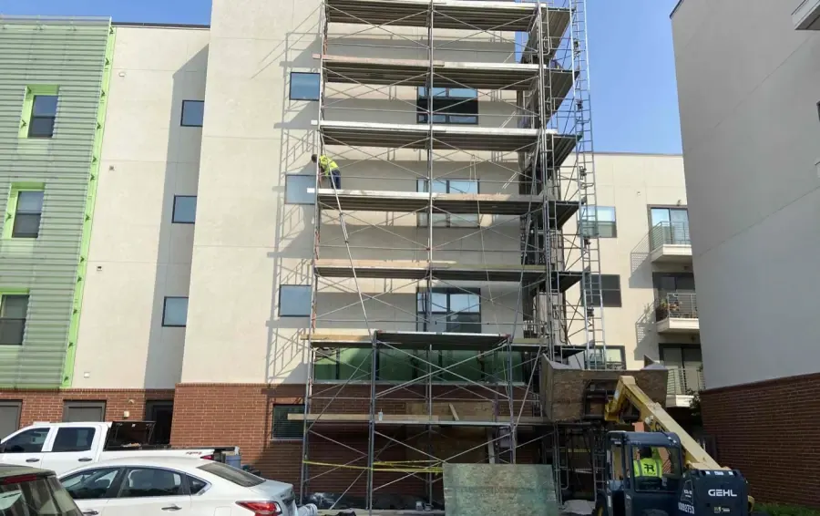 Scaffolding across a multistory facade during exterior recladding