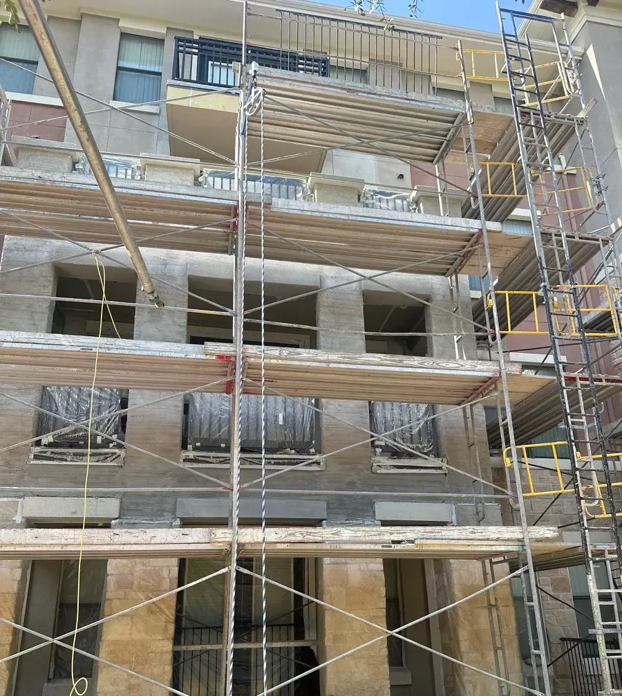 Multistory exterior with exposed wall surfaces and protected openings during repair