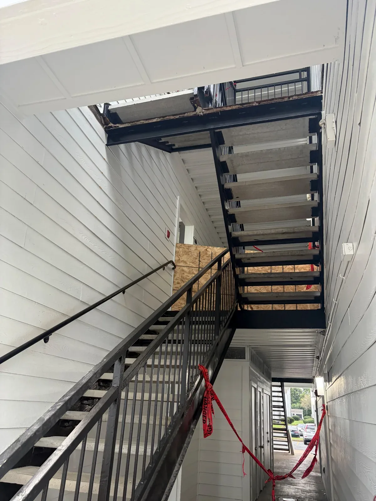 Exterior apartment stairs and landing edges with temporary barriers during reconstruction in Urbana, Illinois.